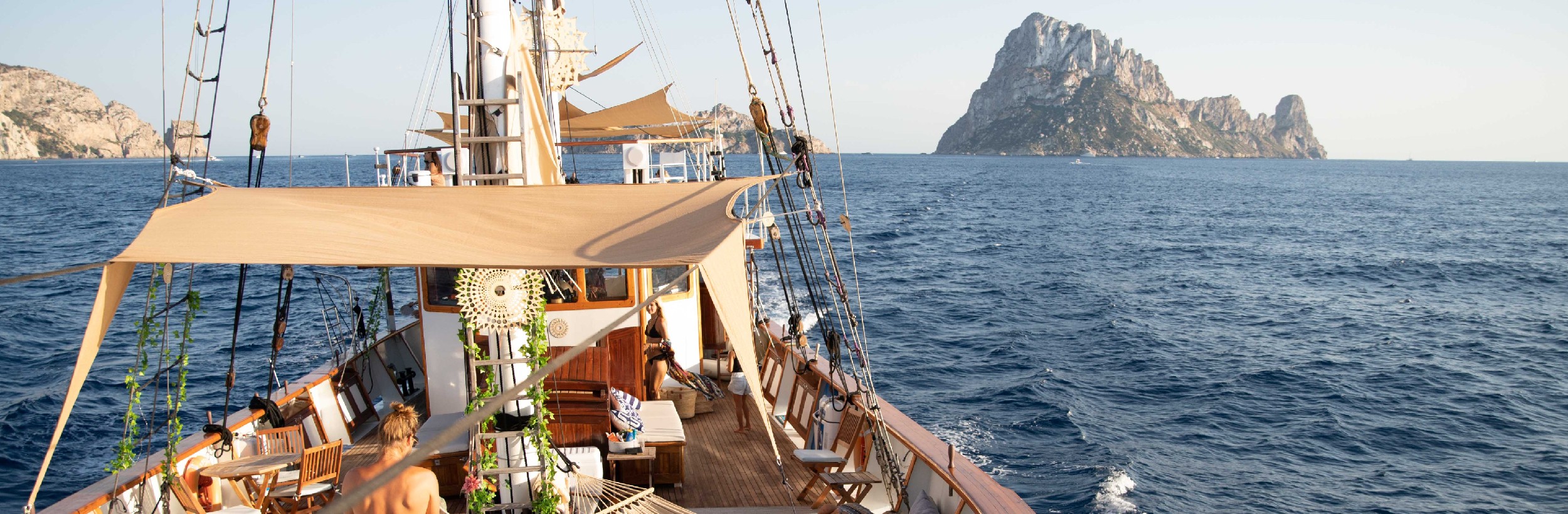 Bow of boat on water with hilly islands on horizon