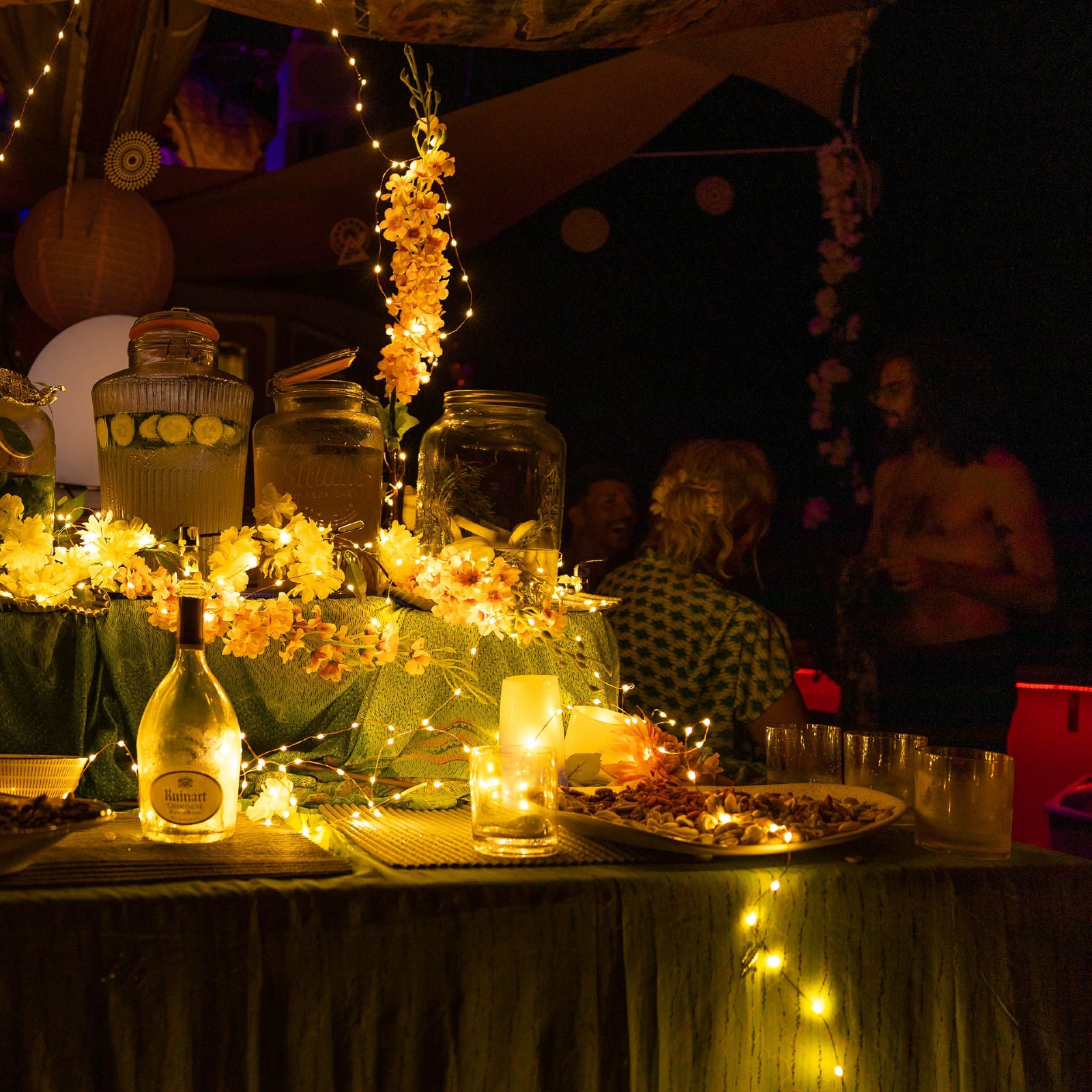 NIght party on boat with table and candles and people in the background